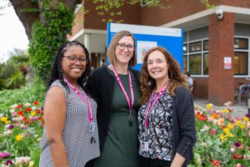 Three Healthwatch staff members standing outside a hospital